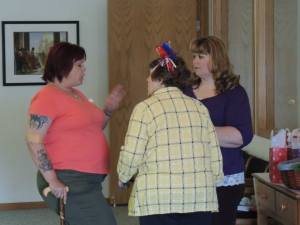 Mary and Stephanie, hostesses, speaking with a guest, Dawn Kelly.